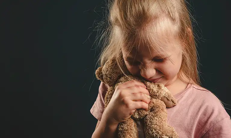 Imagem-de-menina-chorando-e-segurando-urso-de-por-ser-parte-das-estatísticas-tem-direito-a-pensão-para filhos-e-dependentes de-vítimas-de feminicídio